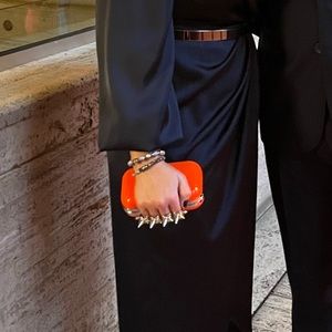 Neon orange spiked knuckle clutch